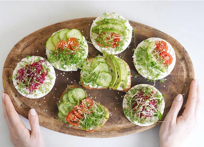 vegan-toasts-made-with-microgreens-on-the-wooden-board-in-female-hands.jpg